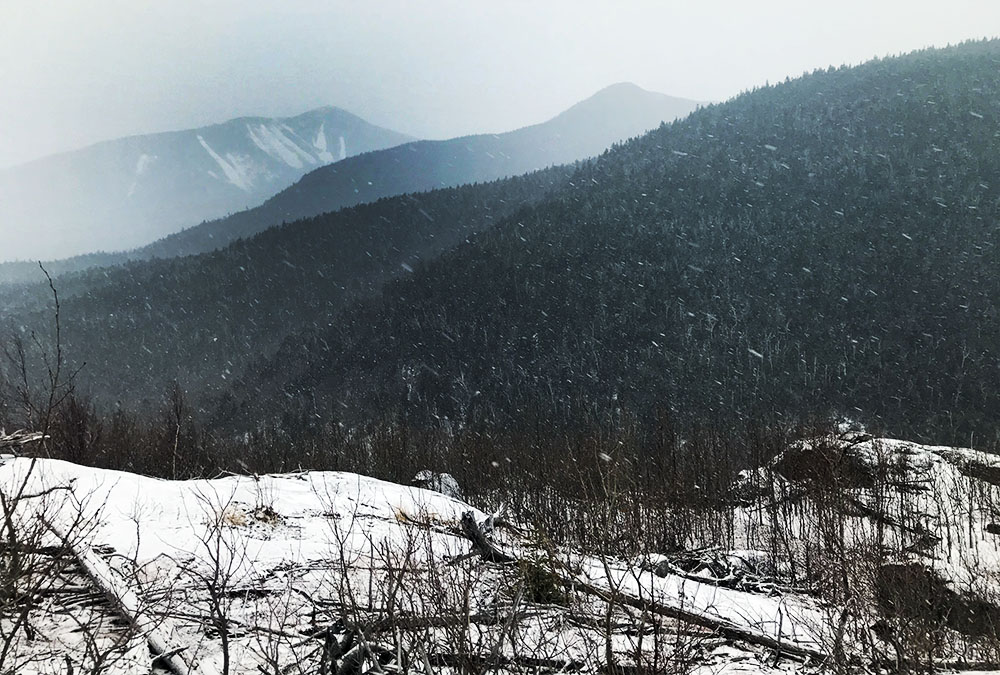 Misty mountains of the Colvin Range, as seen from a rocky outcropping just before Bear Den Mountain.