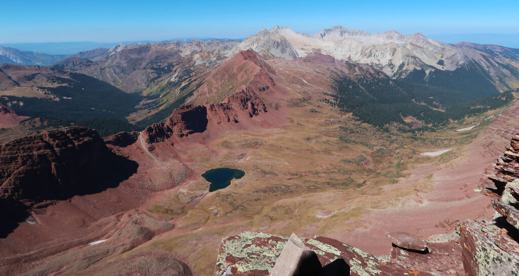 Snowmass and Capitol Peak rise up in the distance across the vast Maroon Bells-Snowmass Wilderness.